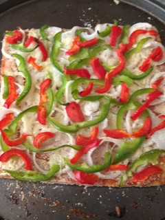 Una foto de Pizza con masa de hojaldre, panceta, queso rallado cebolla y morrón