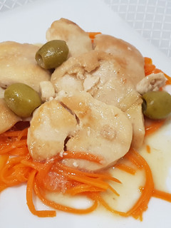Foto di Medaglioni dorati di pollo e tacchino con olive verdi su julienne di carote cotte al vapore