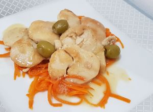 Foto di Medaglioni dorati di pollo e tacchino con olive verdi su julienne di carote cotte al vapore