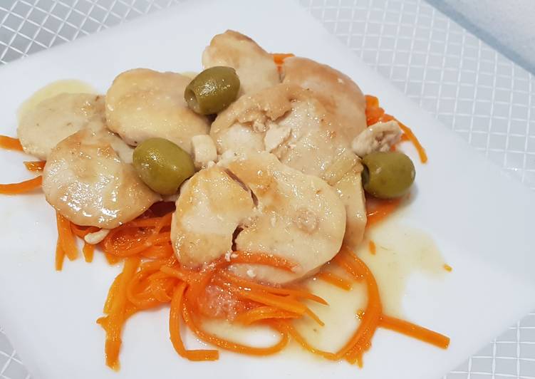 Medaglioni dorati di pollo e tacchino con olive verdi su julienne di carote cotte al vapore