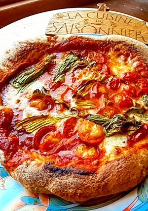 Une photo de Pizza tomates cerises et fleurs de courgettes