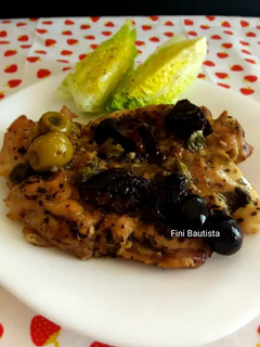 Una foto de Muslos de pollo abiertos al horno con ciruelas y aceitunas
