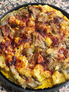 Una foto de Pizza vegana con base de avena y chía y patata con guarnición setas 'A feira'