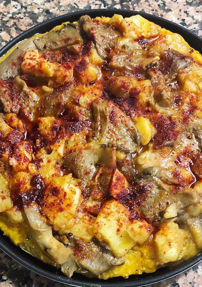 Una foto de Pizza vegana con base de avena y chía y patata con guarnición setas 'A feira'