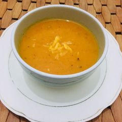 A picture of Tomato soup in cheddar cheese.