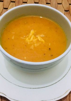 A picture of Tomato soup in cheddar cheese.