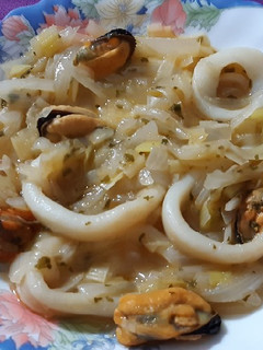 Una foto de Calamares y mejillones con salsa de vino blanco