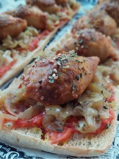 Una foto de Coca de vidre de calamarcitos rellenos de pollo asado y cebolla caramelizada