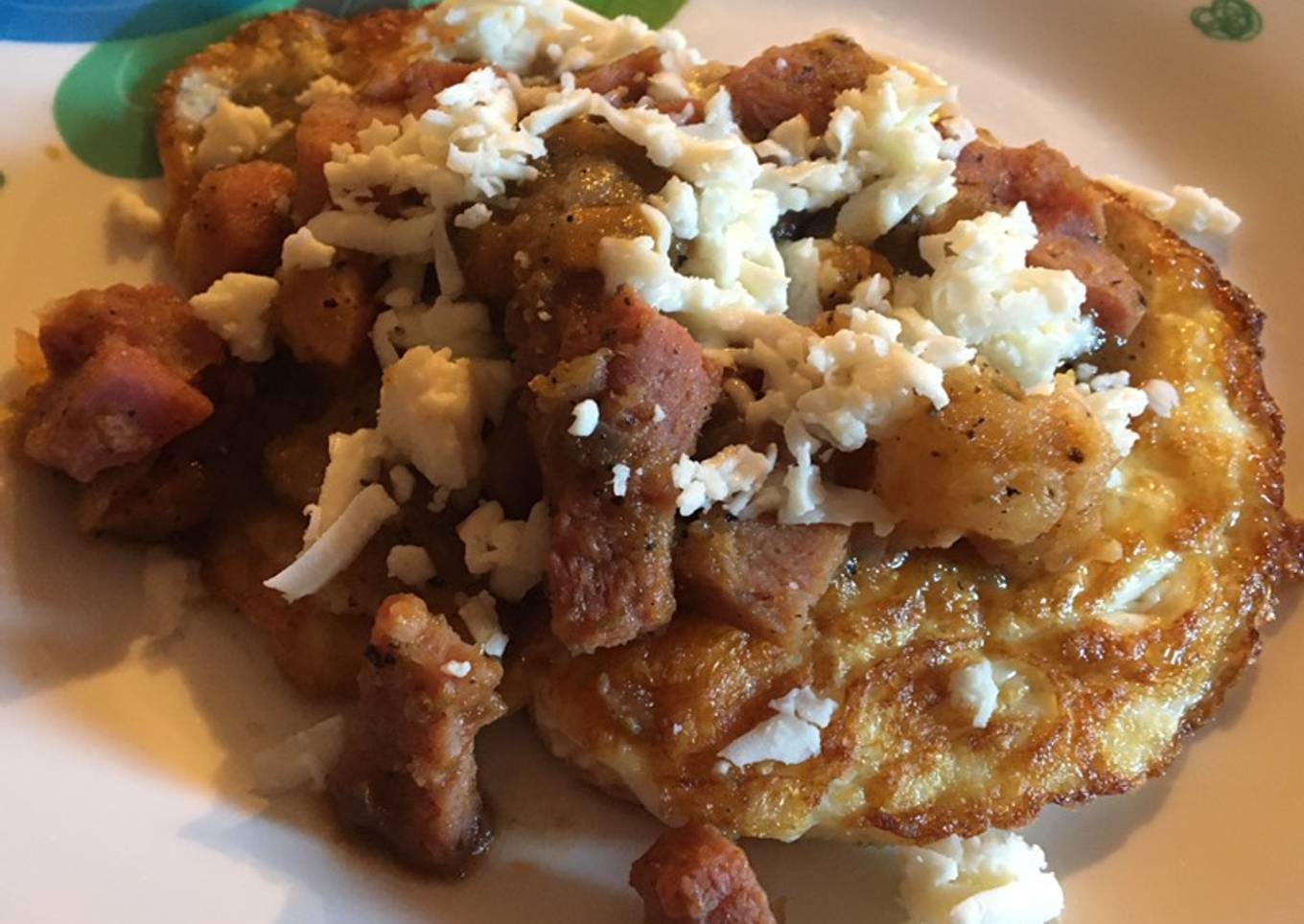 Huevos estrellados bañados en salsa verde con jamón