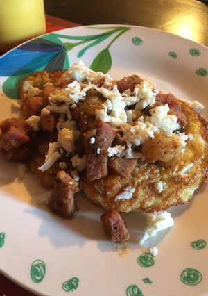 Una foto de Huevos estrellados bañados en salsa verde con jamón
