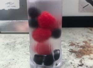 Una foto de Mezcal con frutas del bosque y cardamomo