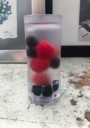 Una foto de Mezcal con frutas del bosque y cardamomo
