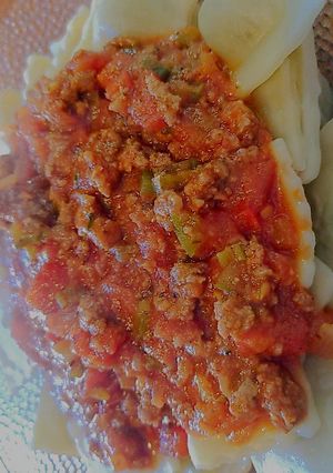 Una foto de Ravioles con salsa boloñesa