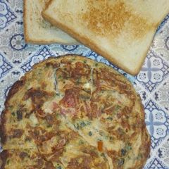 A picture of Green Oinon Omelette With Bread slices.
