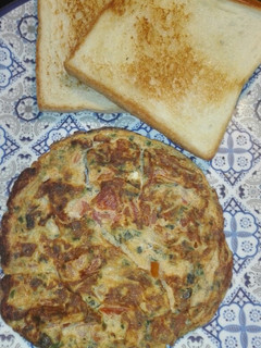 A picture of Green Oinon Omelette With Bread slices.