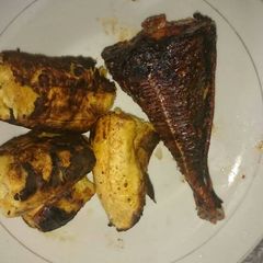 A picture of Fried fish with roasted plantain.