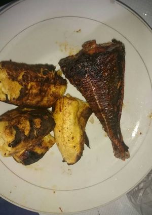A picture of Fried fish with roasted plantain.