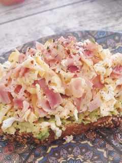 Una foto de Tosta de aguacate y huevos revueltos con jamón cocido