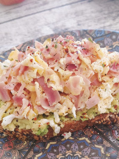 Una foto de Tosta de aguacate y huevos revueltos con jamón cocido