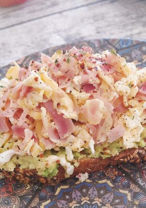 Una foto de Tosta de aguacate y huevos revueltos con jamón cocido
