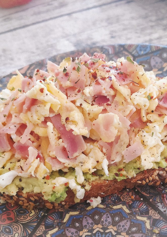Una foto de Tosta de aguacate y huevos revueltos con jamón cocido