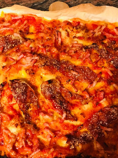Una foto de Pizza masa Fina de jamón ibérico y queso parmesano