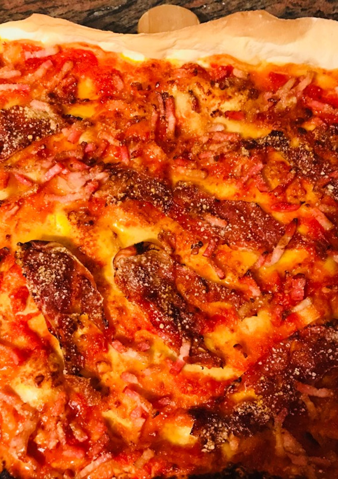 Una foto de Pizza masa Fina de jamón ibérico y queso parmesano