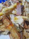 Papas rústicas, tiras de carne, jamón, huevo, queso y cebollas