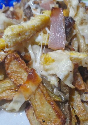 Una foto de Papas rústicas, tiras de carne, jamón, huevo, queso y cebollas