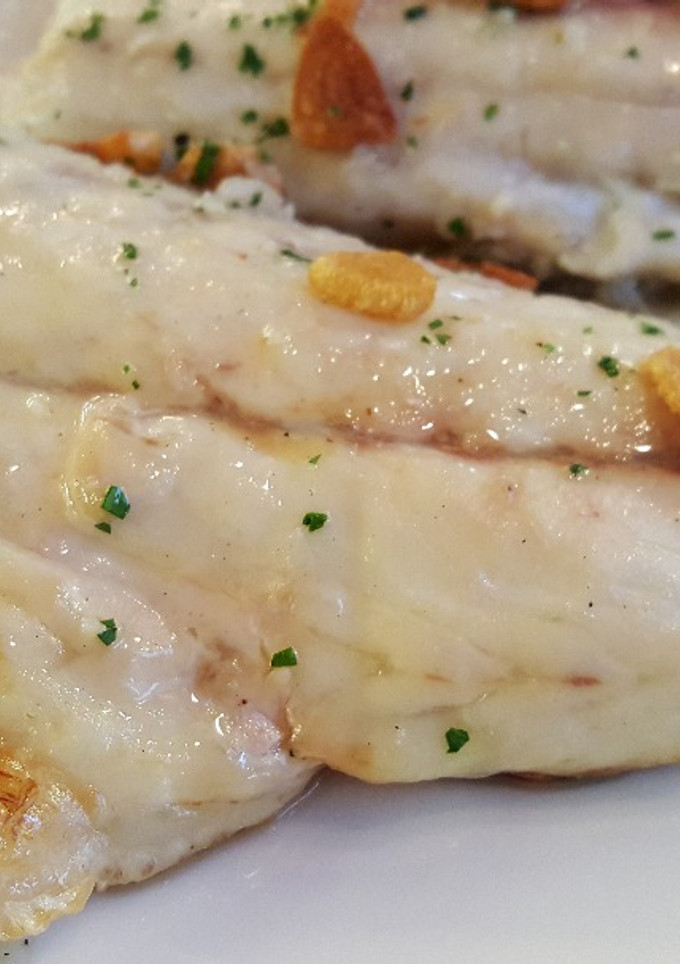 Una foto de Lubina al horno con ajitos y perejil