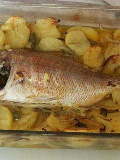 Una foto de Pescado al horno con patatas, cebolla y pimientos