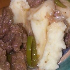 A picture of Cream of mashed potato served with beef stew.