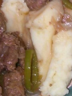 A picture of Cream of mashed potato served with beef stew.