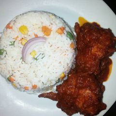 A picture of Boiled rice with tomato sauce.