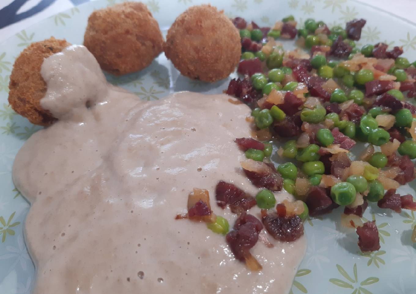 Albóndigas en salsa de champiñones con guisantes y jamón