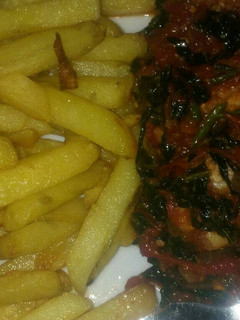 A picture of Chips and tomatoes sauce with shrimps and veggiei.