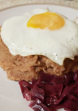A picture of Corned Beef Hash with a fried egg on top.