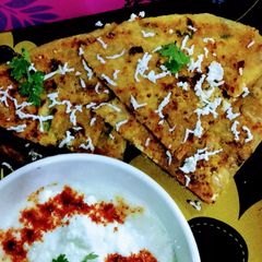 A picture of Paneer onion paratha with melting butter.