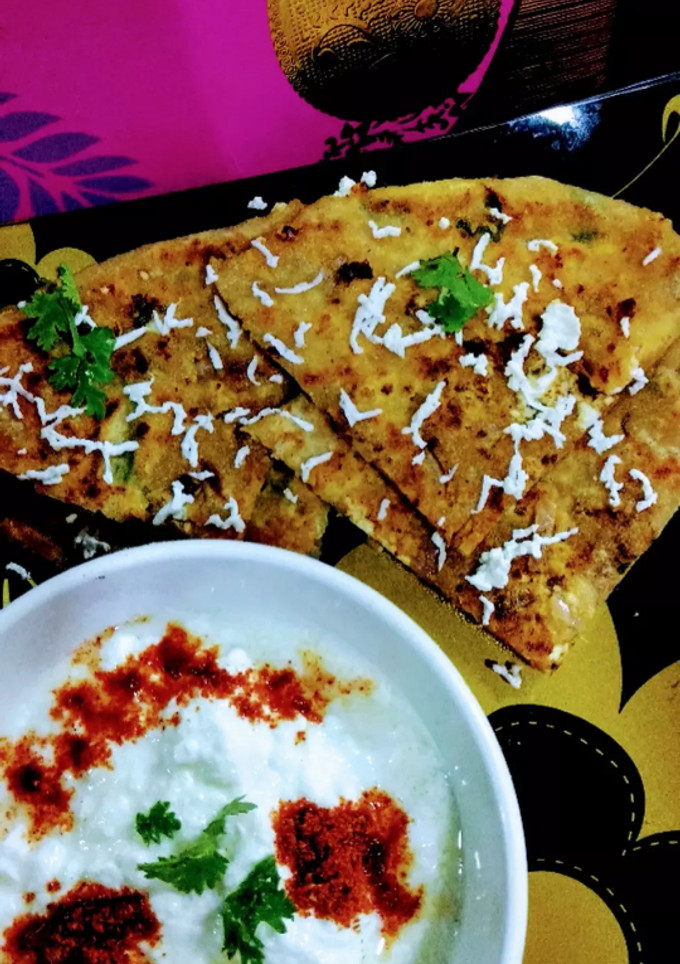 A picture of Paneer onion paratha with melting butter.