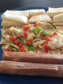 A picture of Fried yam with fried egg and sausages.