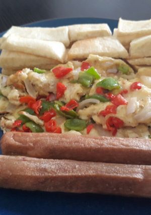 A picture of Fried yam with fried egg and sausages.