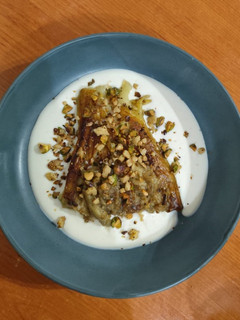 Una foto de Berenjena asada con salsa de ricotta y pistachos