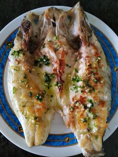 Una foto de Lubina con picada de ajos y perejil