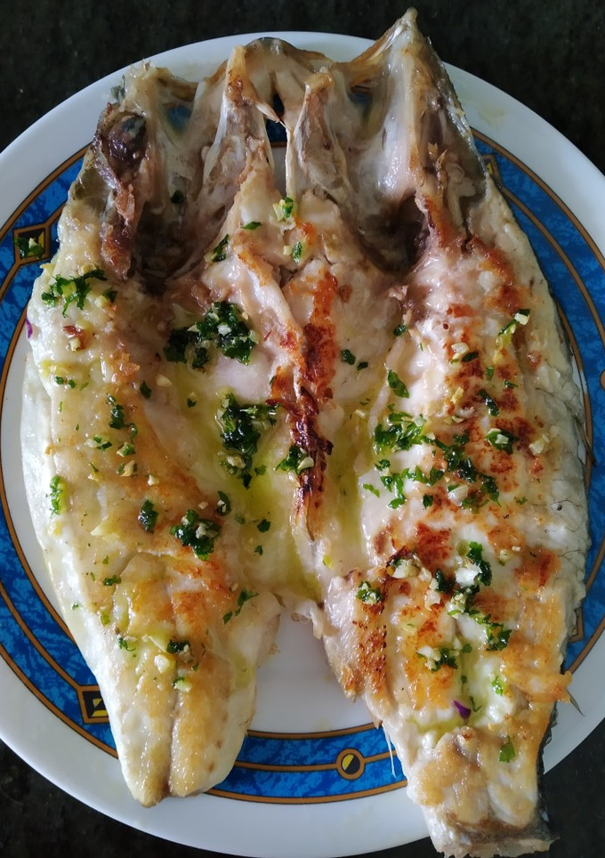 Una foto de Lubina con picada de ajos y perejil