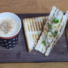 A picture of Chicken cheese grilled sandwiches with cappuccino.