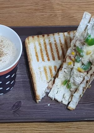 A picture of Chicken cheese grilled sandwiches with cappuccino.
