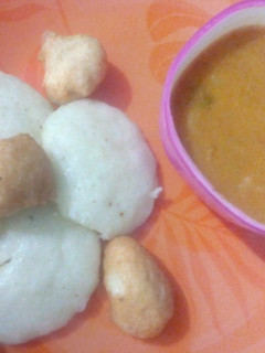 A picture of Sambhar with vada and idli.