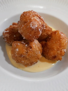 Una foto de Buñuelos de manzana y nueces sobre crema inglesa
