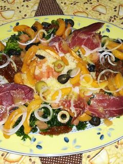 Una foto de Ensalada de kale con cuscus, nísperos y paleta iberica