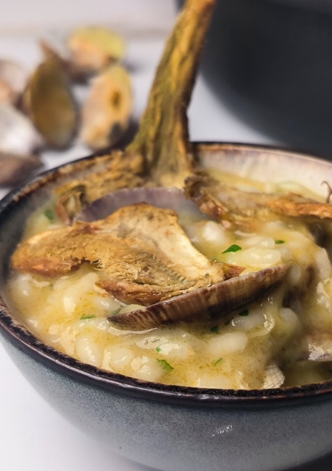 Una foto de Arroz en salsa verde con almejas y alcachofas